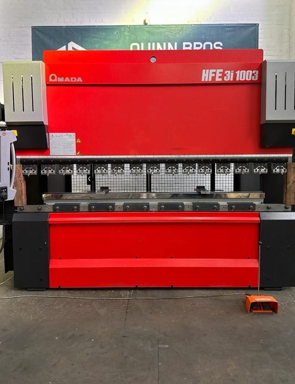 One of our Amada press brakes on the floor, whole machine in frame, control panel visible.