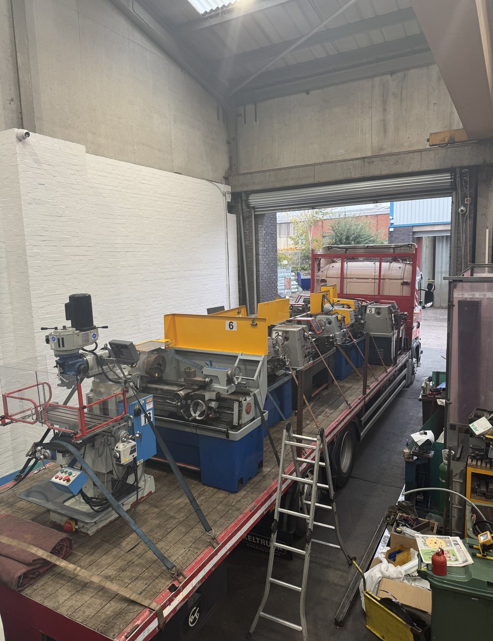 A full workshop from the doorway. Busy, plant everywhere, the job in front of you.