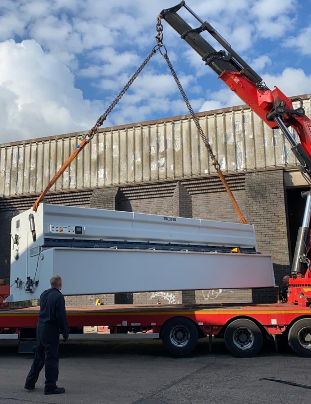 A machine strapped down on a lorry, ready to leave. Straps and chocks visible.