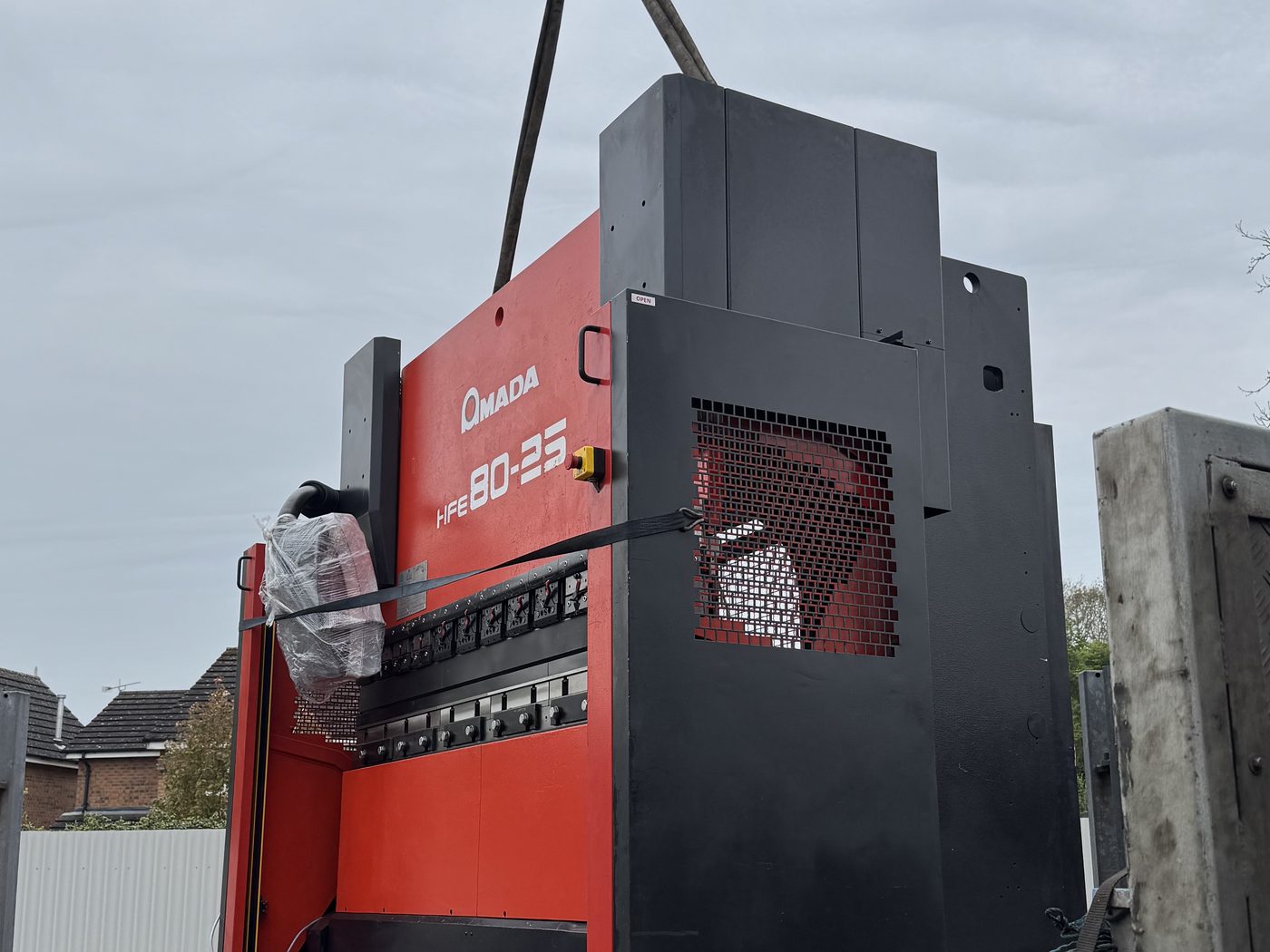 A machine in the air on a HIAB or crane, being lifted off or onto the lorry.